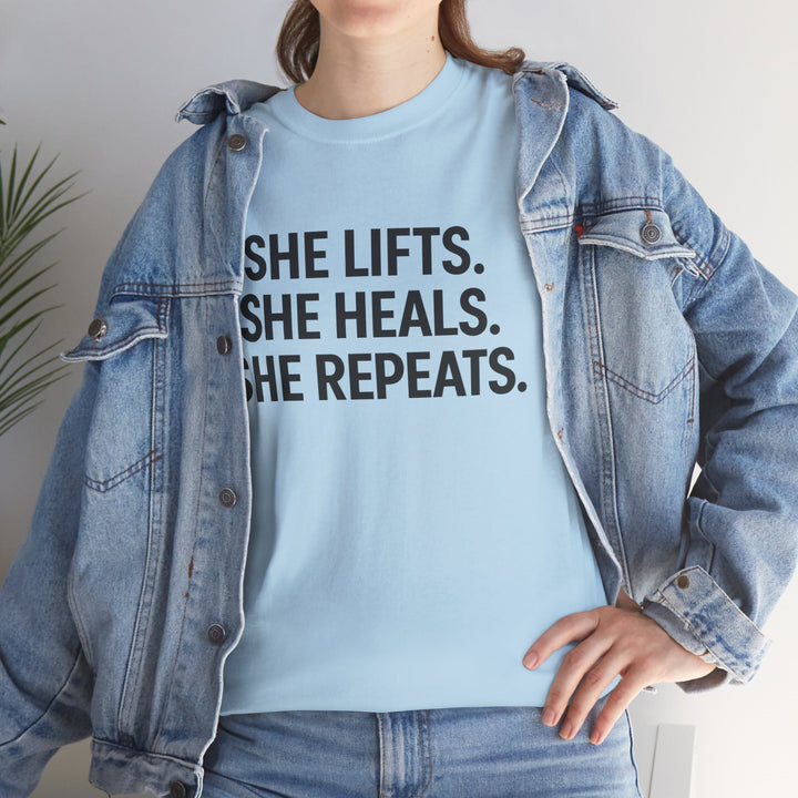 She Lifts. She Heals. She Repeats.  Unisex Heavy Cotton Tee