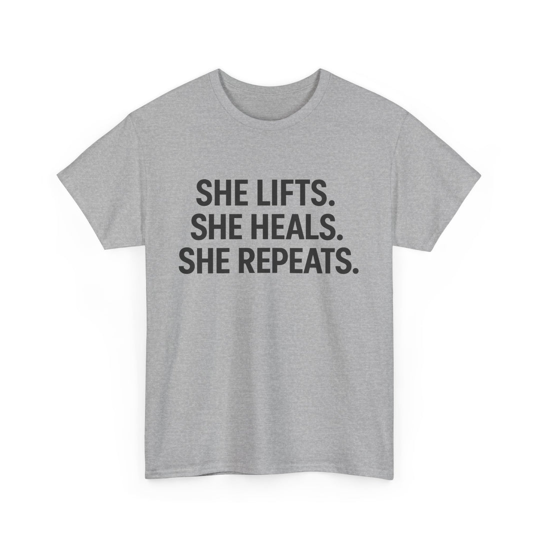 She Lifts. She Heals. She Repeats.  Unisex Heavy Cotton Tee