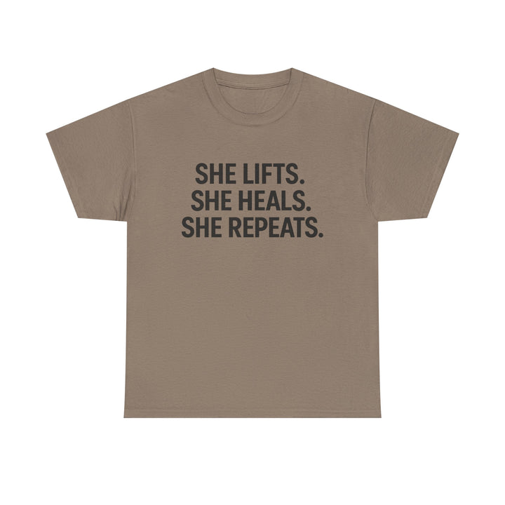 She Lifts. She Heals. She Repeats.  Unisex Heavy Cotton Tee