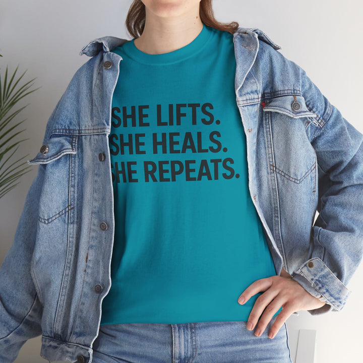 She Lifts. She Heals. She Repeats.  Unisex Heavy Cotton Tee