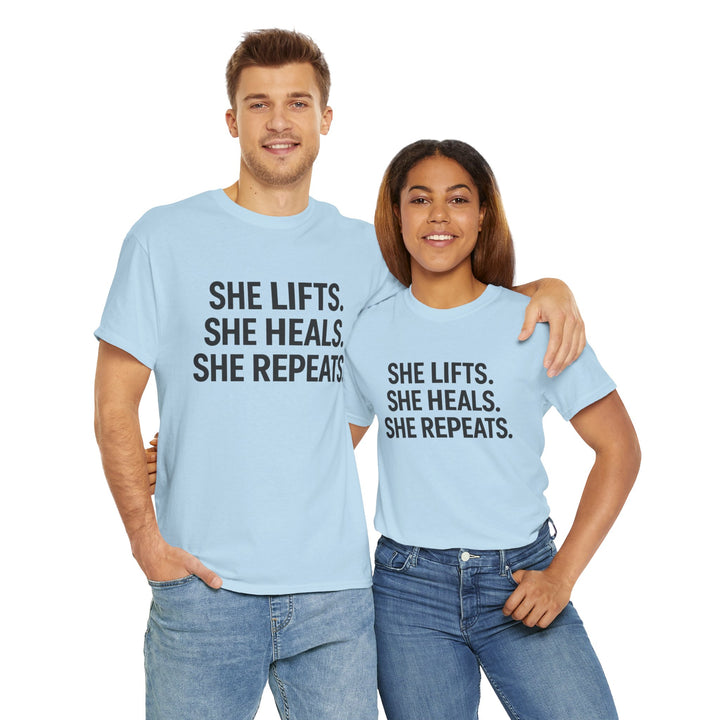She Lifts. She Heals. She Repeats.  Unisex Heavy Cotton Tee