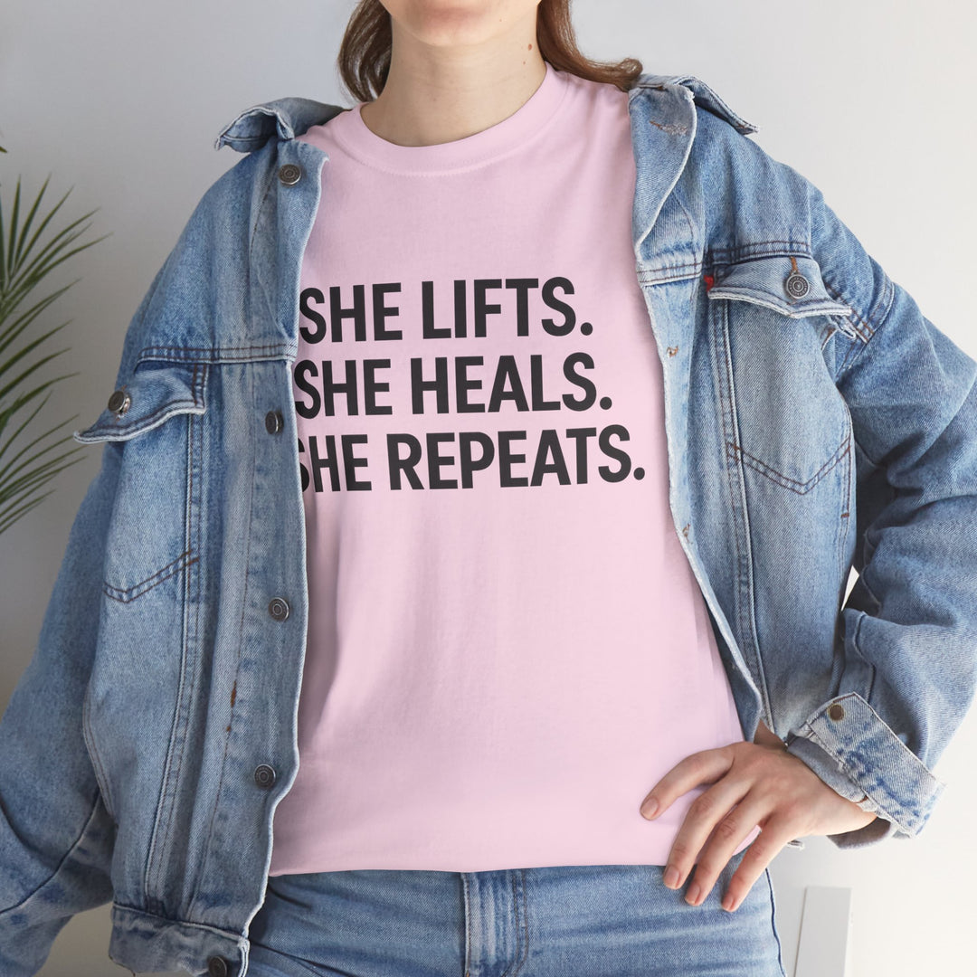 She Lifts. She Heals. She Repeats.  Unisex Heavy Cotton Tee