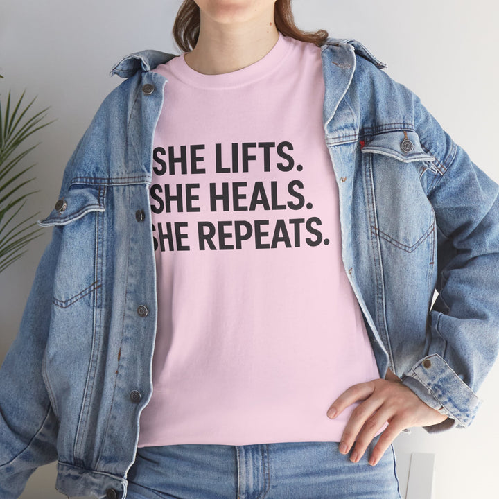 She Lifts. She Heals. She Repeats.  Unisex Heavy Cotton Tee