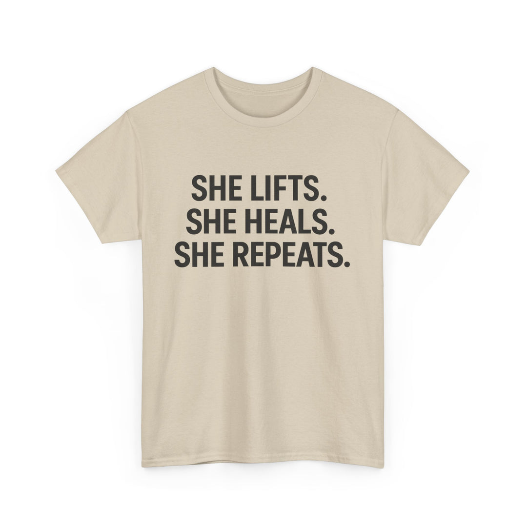 She Lifts. She Heals. She Repeats.  Unisex Heavy Cotton Tee