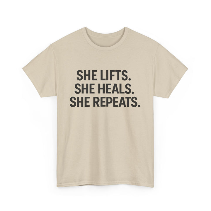 She Lifts. She Heals. She Repeats.  Unisex Heavy Cotton Tee