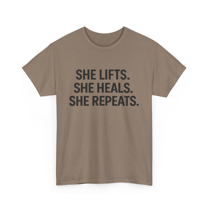 She Lifts. She Heals. She Repeats.  Unisex Heavy Cotton Tee