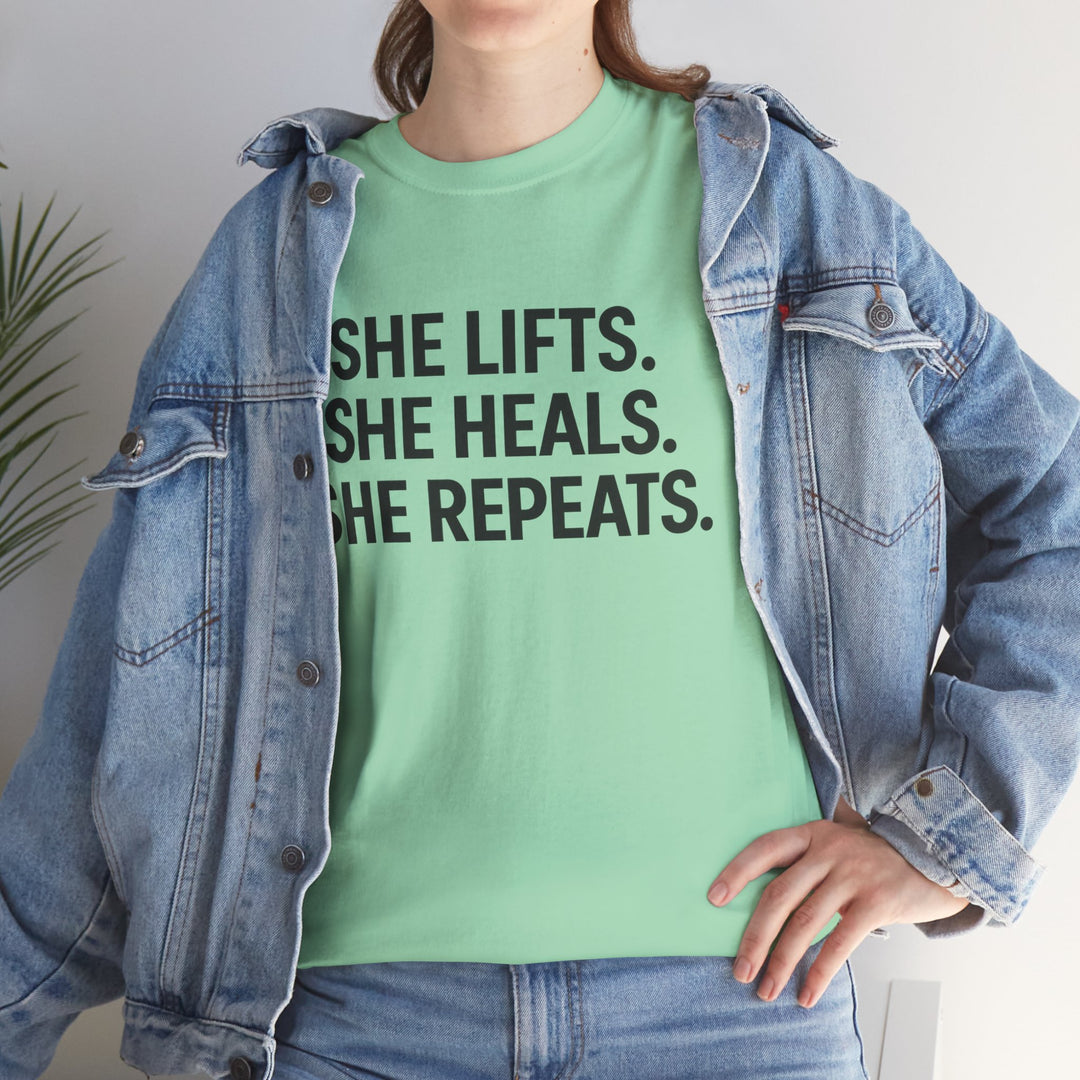 She Lifts. She Heals. She Repeats.  Unisex Heavy Cotton Tee