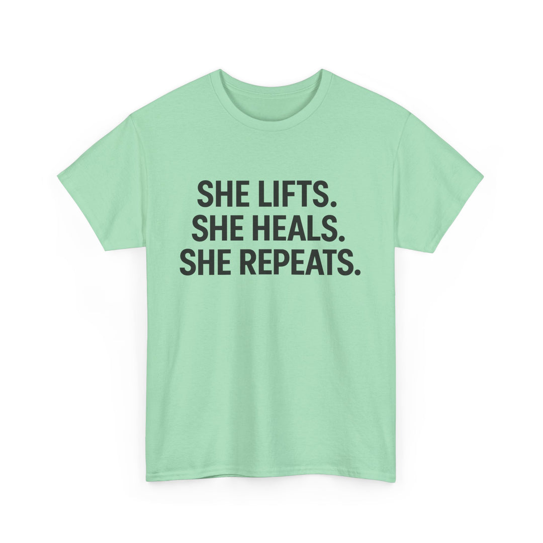 She Lifts. She Heals. She Repeats.  Unisex Heavy Cotton Tee