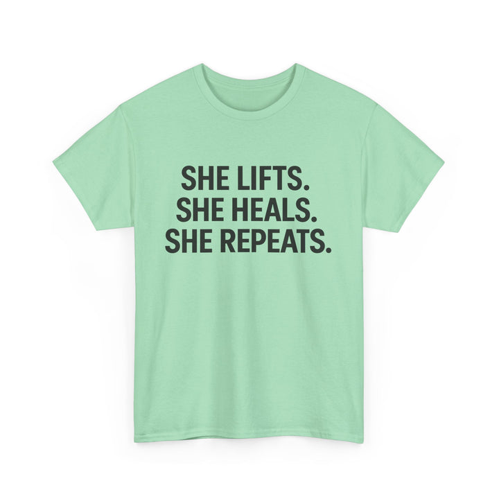 She Lifts. She Heals. She Repeats.  Unisex Heavy Cotton Tee