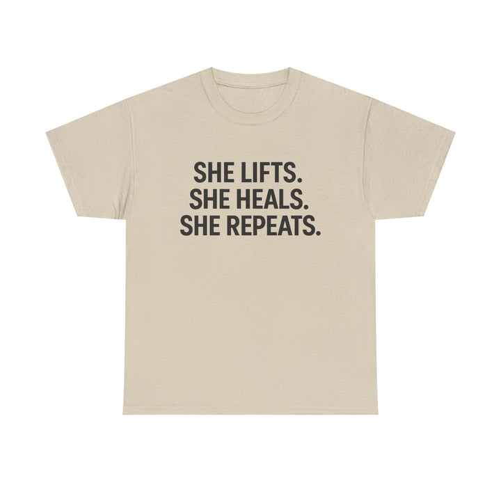 She Lifts. She Heals. She Repeats.  Unisex Heavy Cotton Tee