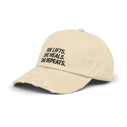 She Lifts. She Heals. She Repeats. : Unisex Distressed Cap