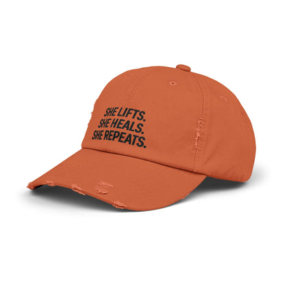 She Lifts. She Heals. She Repeats. : Unisex Distressed Cap