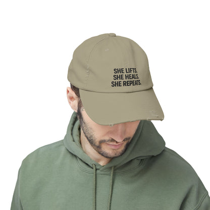 She Lifts. She Heals. She Repeats. : Unisex Distressed Cap